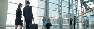 Business professionals walking in a glass building lobby